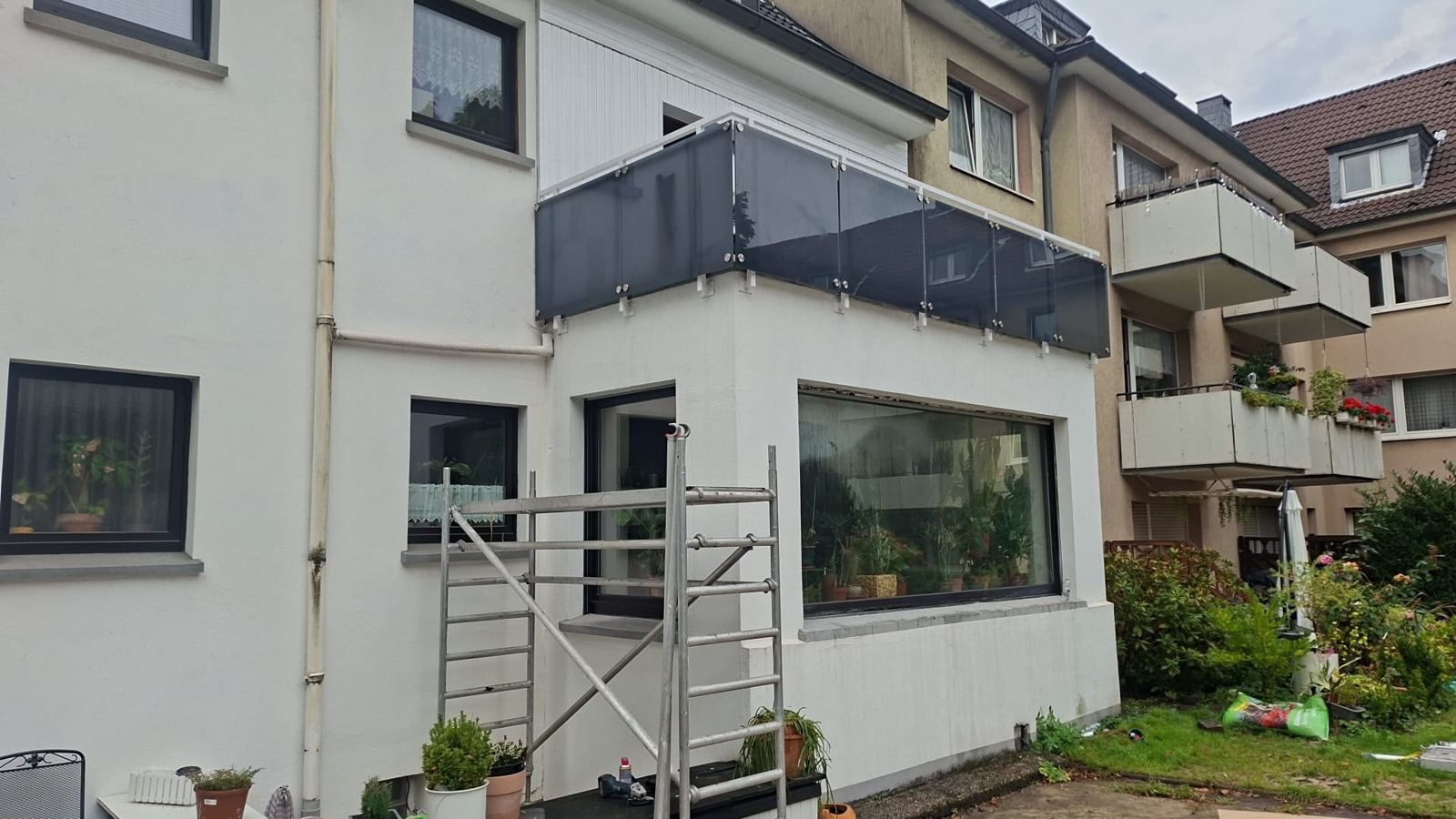 Sanierter Balkon mit neuer Brüstung aus mattem Sicherheitsglas
