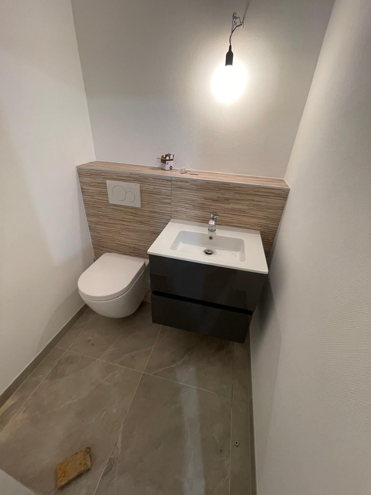Gäste-WC: Wand-WC und Waschtisch mit Holzverkleidung